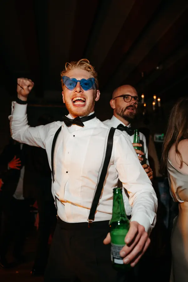 Brudgom danser med solbriller under bryllupsfesten.