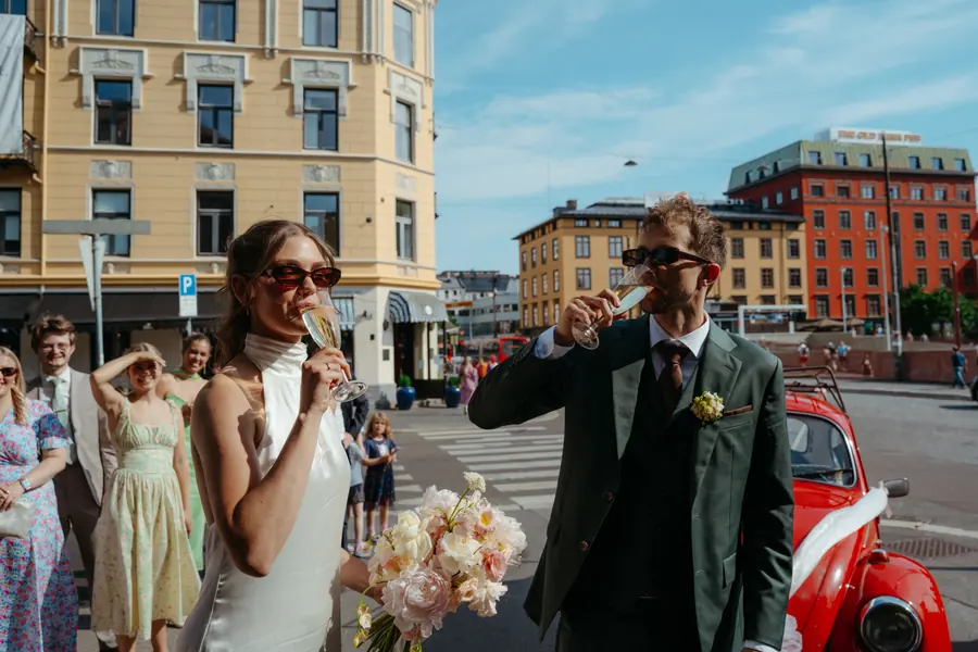 Brudepar og venner skåler med champagne i byen.